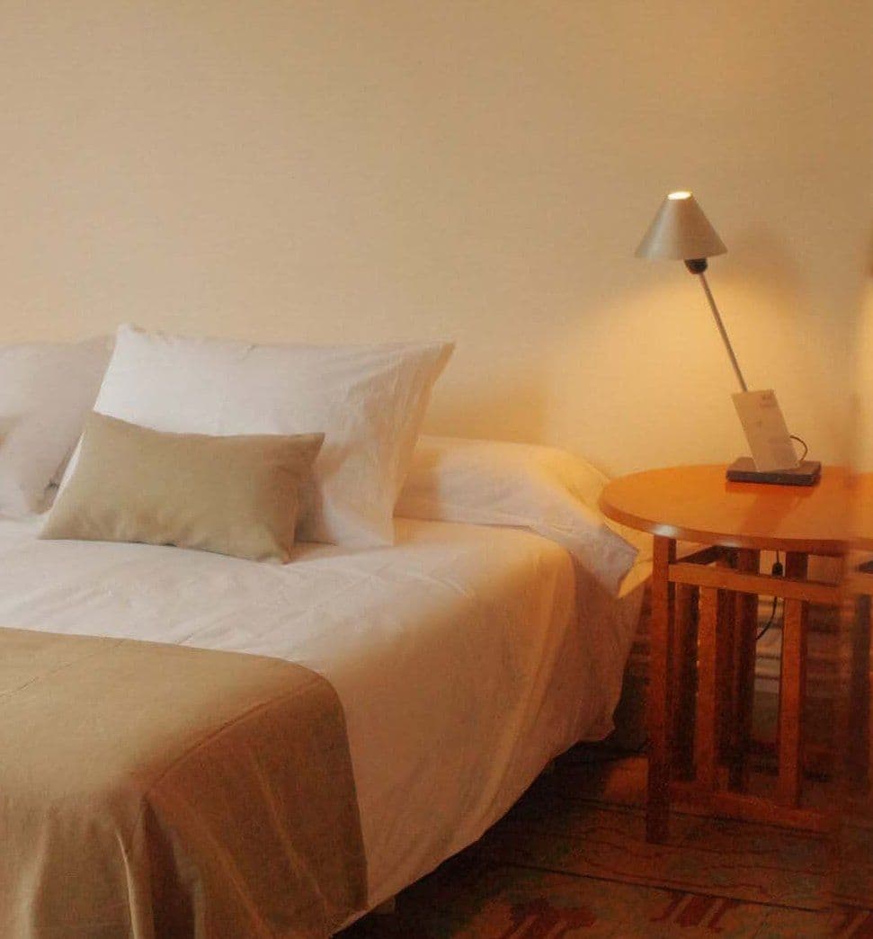 Bedroom with a double bed and a reading lamp switched on