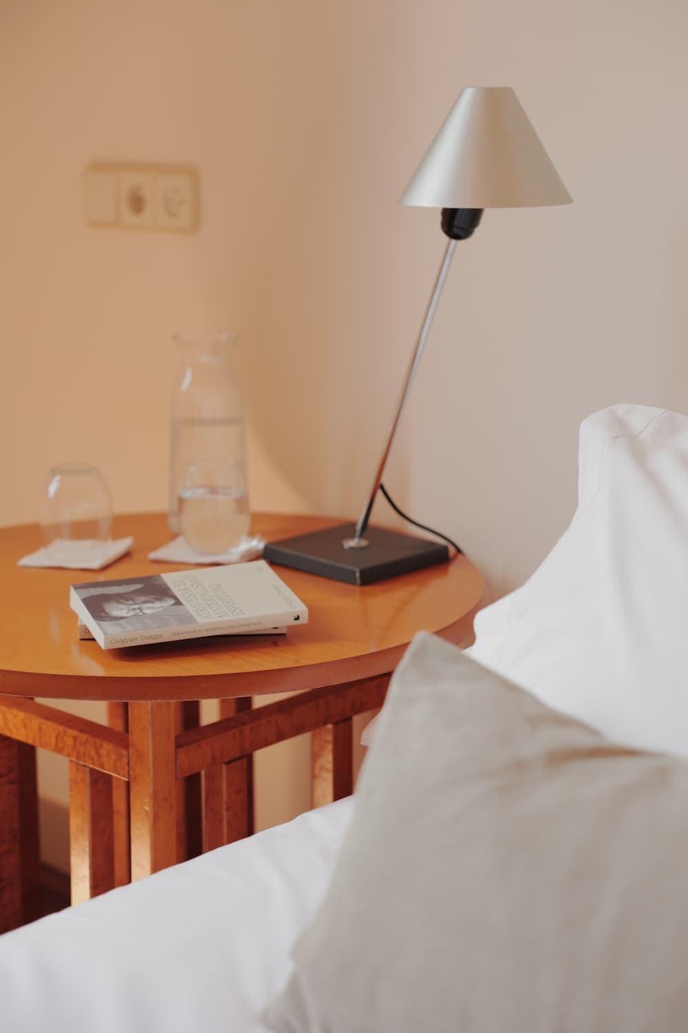 Wooden bedside table with a lamp and a water jug