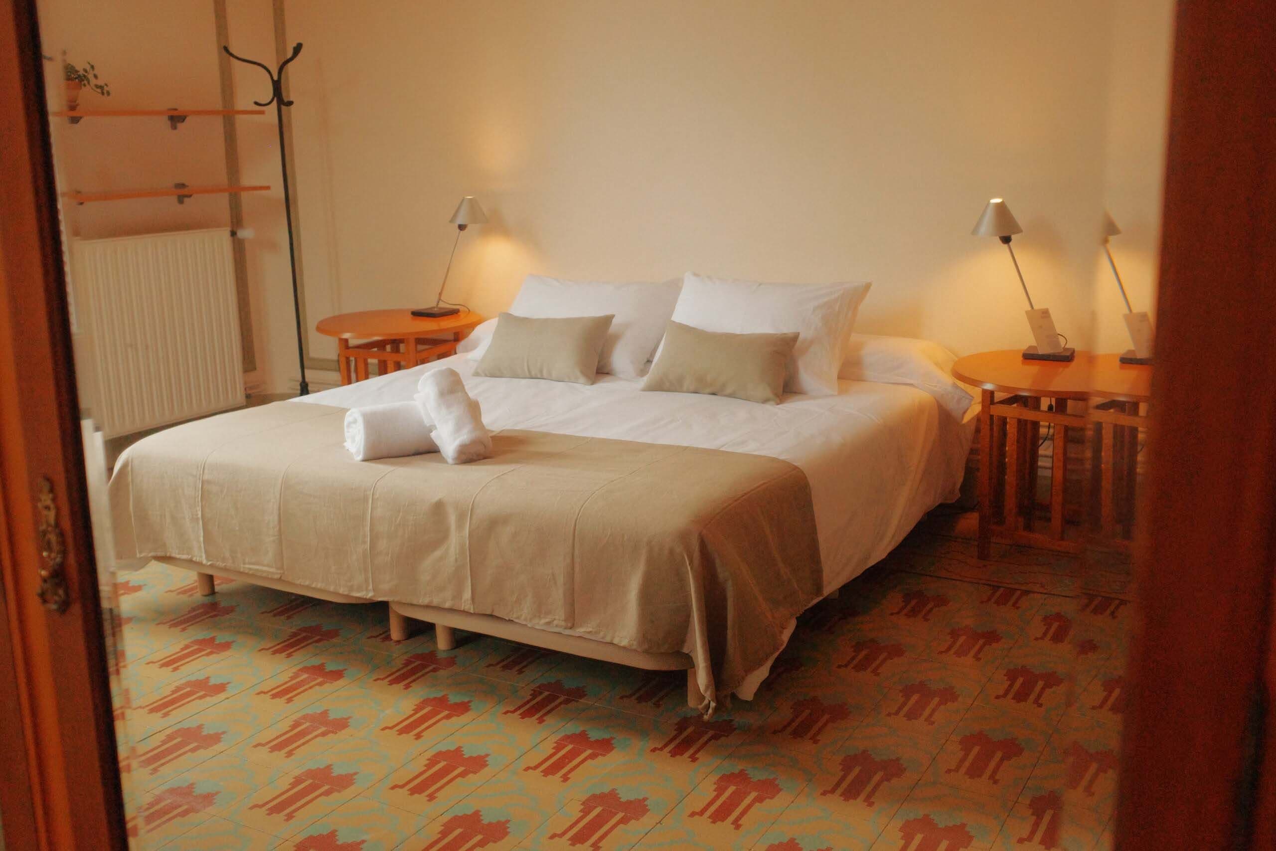 Double room with bed linen and towels folded on the bedspread