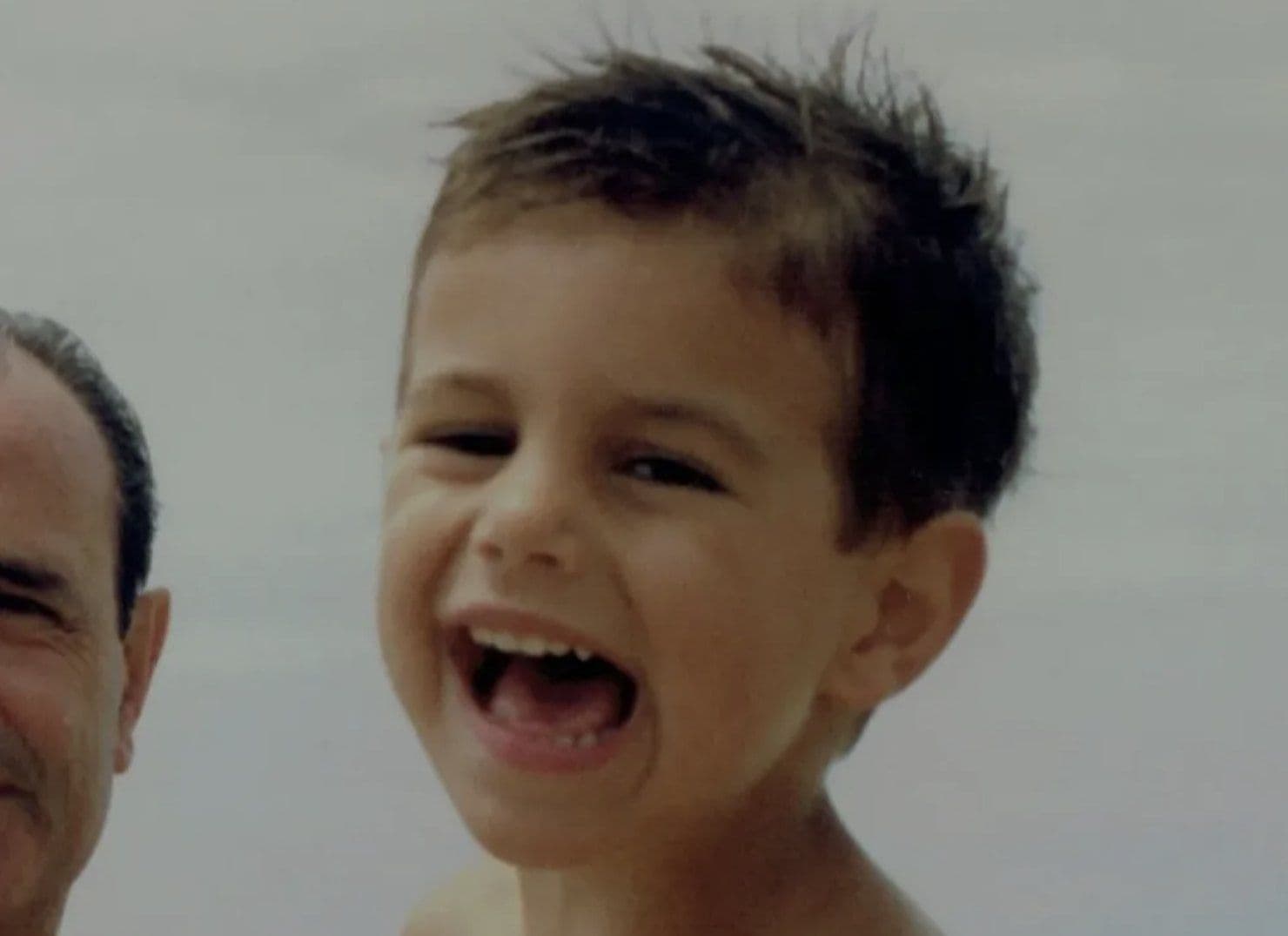 Lama Norbu as a child, laughing on the beach